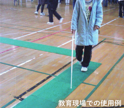 教育現場での使用例として、体育館に設置した誘導マットの上を白杖を使って歩く子どもたち。